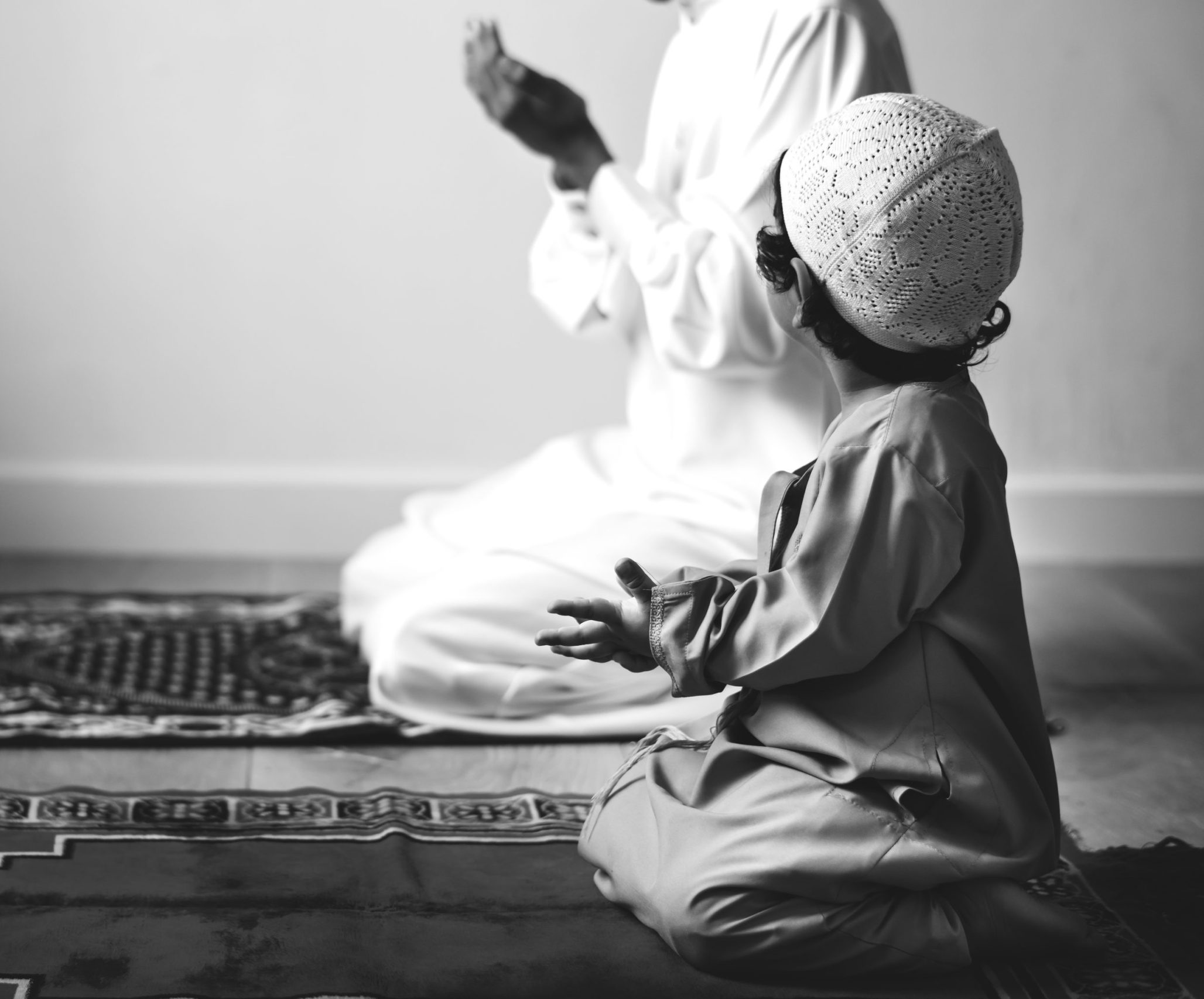 Muslim boy learning how to make Dua to Allah